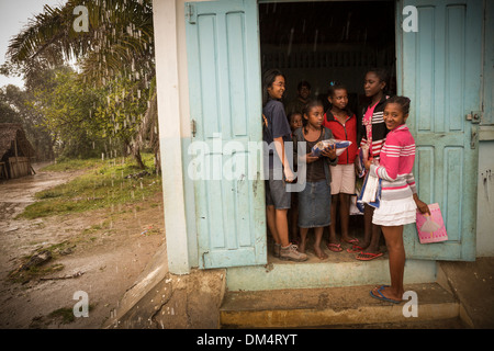 Kinder warten in der Tür einer Schule in Fenerive Est, Madagaskar. Stockfoto