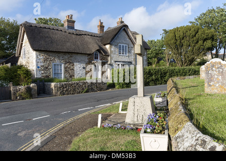 Strohgedeckte Haus gebaut aus Naturstein gegenüber Str. Marys Kirche im Dorf Brighstone auf der Isle Of Wight, England Stockfoto