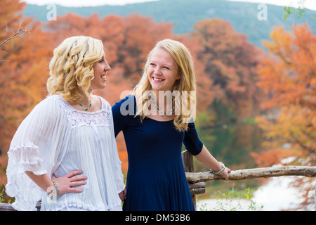 Outdoor-Porträt von zwei Mädchen, 16 Jahre alt, kaukasischen Ethnicity, stehend im Freien mit Herbst Bäume im Hintergrund gefärbt, Stockfoto