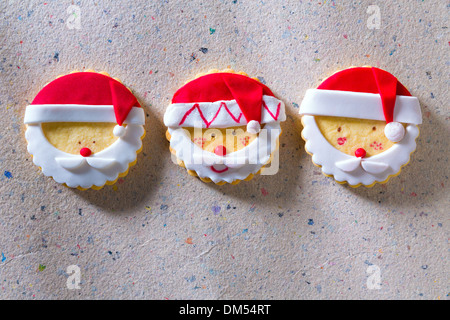 Weihnachtsplätzchen mit Santa Gesicht in einer Reihe auf Recycling-Papier-Hintergrund Stockfoto