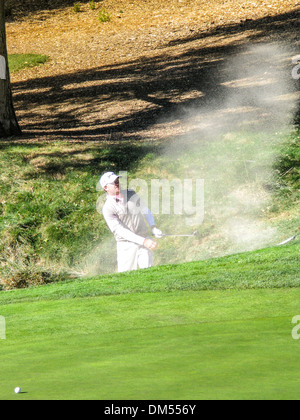 Ein Amateur schlagen aus einem Bunker am ersten Loch von der nordwestlichen gegenseitige World Challenge 2013 mit Tiger Woods Stockfoto