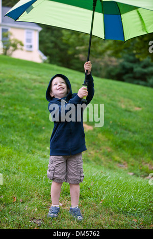 Kleiner Junge mit Schirm in Außenluft Stockfoto