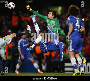 (131212) - LONDON, 12. Dezember 2013 (Xinhua)--Demba Ba (unten) von Chelsea wetteifert mit Ciprian Tatarusanu (oben), Torwart des FC Steaua Bukarest, während der UEFA Champions League-Gruppe E-Partie zwischen Chelsea und FC Steaua Bukarest bei Stamford Bridge Stadium in London, Großbritannien, am 11. Dezember 2013. Chelsea gewann 1: 0. (Xinhua/Wang Lili) Stockfoto