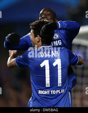 (131212) - LONDON, 12. Dezember 2013 (Xinhua)--Demba Ba (oben) von Chelsea feiert erzielte mit seinem Teamkollegen Oscar während der UEFA Champions League-Gruppe E-Partie zwischen Chelsea und FC Steaua Bukarest bei Stamford Bridge Stadium in London, Großbritannien, am 11. Dezember 2013. Chelsea gewann 1: 0. (Xinhua/Wang Lili) Stockfoto