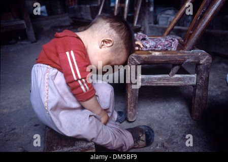 Ein kleines Kind nehmen ein Nickerchen am Nachmittag nach dem Mittagessen in der Provinz Hunan, China Stockfoto