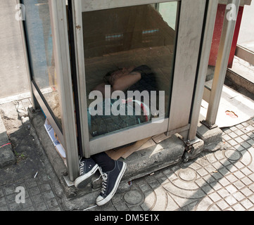 Junge schläft in Telefonzelle, Nana Plaza, Bangcock, Thailand. Stockfoto