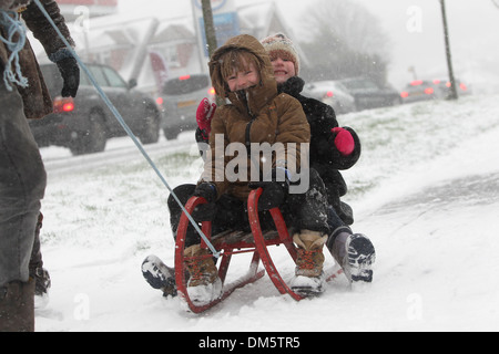 Zwei Kinder, die im Bild auf einem Schlitten in schweren gezogen Schnee in Brighton, East Sussex. Stockfoto