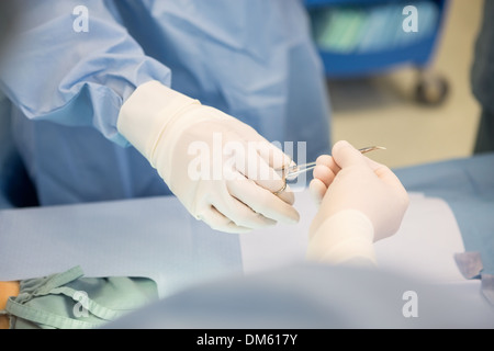 Chirurgen, chirurgische Scheren während der Operation übergeben Stockfoto