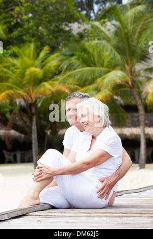 Senior paar sitzt am Holzsteg Stockfoto