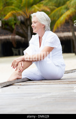 Senior Woman Sitting On Holzsteg Stockfoto