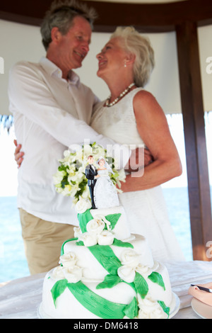 Senior-Strand-Hochzeits-Zeremonie mit Kuchen im Vordergrund Stockfoto