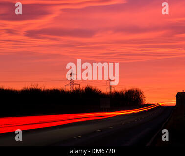 Seal Sands Road in der Nähe Billingham, UK. 12. Dezember 2013. Verkehr in Richtung Seal Sands Petro chemische komplexe bei Sonnenaufgang, als der Himmel mit Farbe auf Nebel Vormittag zur freien Verfügung im Nordosten von England Credit explodiert: ALANDAWSONPHOTOGRAPHY/Alamy Live News Stockfoto