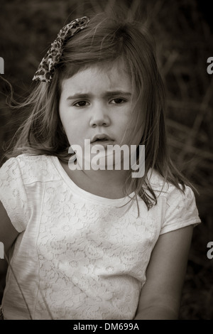 Junges Mädchen im weißen Kleid unter Heu Ballen in einer Scheune. Stockfoto