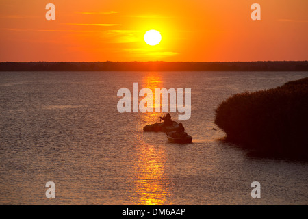 Angler mit Booten bei Sonnenuntergang auf den Bodstedter Bodden Lagune, in der Nähe von Wieck, Mecklenburg-Western Pomerania, Deutschland Stockfoto