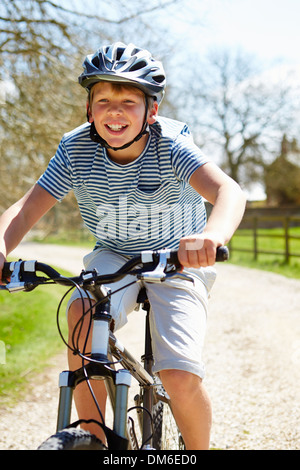 Kleiner Junge mit Fahrrad auf Land-Strecke Stockfoto