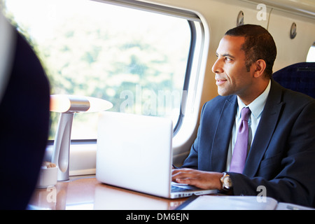 Geschäftsmann pendeln zur Arbeit auf dem Zug und mit Laptop Stockfoto