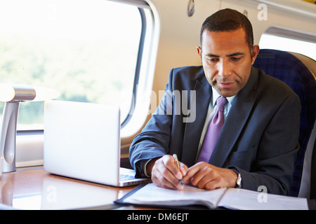 Geschäftsmann pendeln zur Arbeit auf dem Zug und mit Laptop Stockfoto