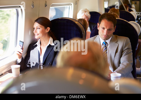 Geschäftsfrau, die Fahrt zur Arbeit auf Zug mit Handy Stockfoto