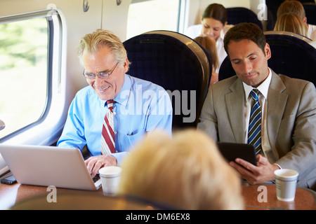 Geschäftsmann pendeln zur Arbeit auf dem Zug und mit Laptop Stockfoto