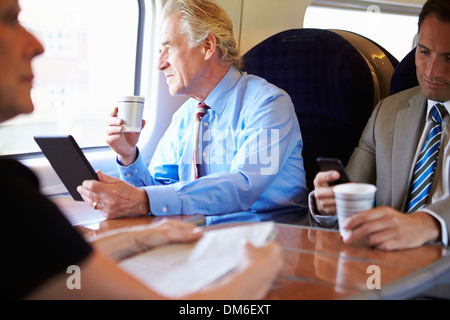 Geschäftsmann am Zug mit Tasse Kaffee entspannen Stockfoto