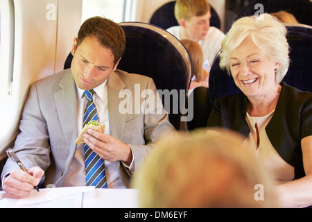 Kaufmann Essen Sandwich auf Zugfahrt Stockfoto