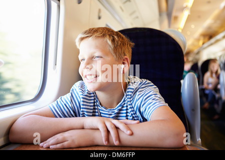 Junge Musik hören auf Zugfahrt Stockfoto