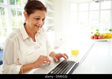 Hochrangige indische Frau mit Laptop zu Hause Stockfoto