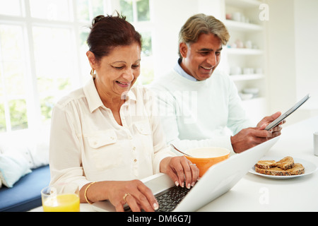 Hochrangige indische paar mit Laptop und Digital-Tablette zu Hause Stockfoto