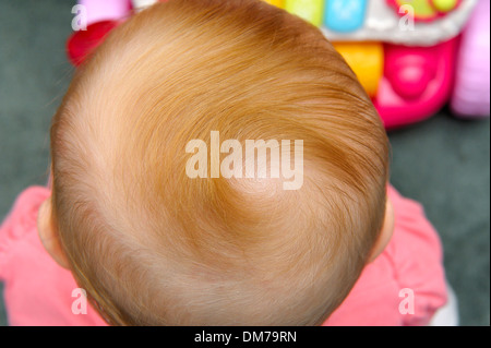 Krone von einem 10 Monate alten Baby Mädchen mit Ingwer Haar Stockfoto