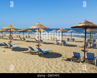 Strand-Sonnenschirme und Liegestühle am Strand von Analipsi auf Kreta Stockfoto