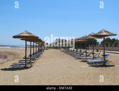 Strand-Sonnenschirme und Liegestühle am Strand von Analipsi auf Kreta Stockfoto