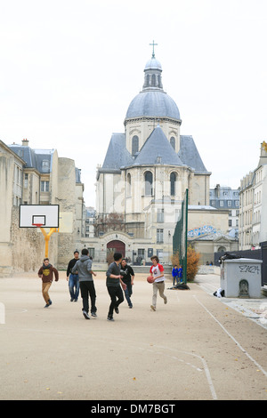 Teenager spielen Basketball am Sportplatz infront des Lycée Charlemagne Schule. Paris, Frankreich, Europa Stockfoto