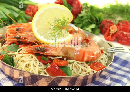 Garnelen mit Mie-Nudeln, Zitrone, Paprika, Lauch, Dill und Koriander auf hellem Hintergrund Stockfoto