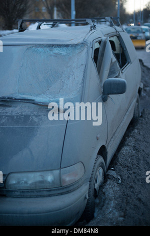 Mini-van aus dem Schnee nach einem langen Winter erscheinen beschädigt stark Stockfoto