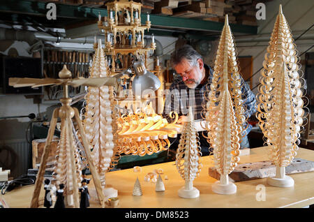 Einsiedel, Deutschland. 10. Dezember 2013. Drechsler Steffen Goethel Handwerk eine so genannte "Spanbaum" in der Kunst und Handwerk Werkstatt Werner Gloess in Einsiedel, Deutschland, 10. Dezember 2013. Ein "Spanbaum" ist eine traditionelle hölzerne Weihnachtsdekoration aus dem Erz Bergregion, umfasst die Gestaltung und Formung von Holzspänen in einen Weihnachtsbaum. Heute nur sehr wenige lokale Kunsthandwerker in der Lage Beherrschung dieser Art des Handwerks, die an der familiengeführte Kunst produziert wird und Handwerk Werkstatt Werner Gloess seit 60 Jahren. Foto: Jan Woitas/Dpa/Alamy Live News Stockfoto