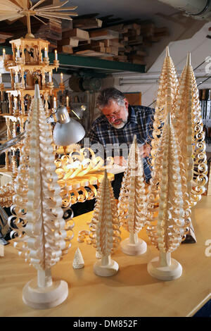 Einsiedel, Deutschland. 10. Dezember 2013. Drechsler Steffen Goethel Handwerk eine so genannte "Spanbaum" in der Kunst und Handwerk Werkstatt Werner Gloess in Einsiedel, Deutschland, 10. Dezember 2013. Ein "Spanbaum" ist eine traditionelle hölzerne Weihnachtsdekoration aus dem Erz Bergregion, umfasst die Gestaltung und Formung von Holzspänen in einen Weihnachtsbaum. Heute nur sehr wenige lokale Kunsthandwerker in der Lage Beherrschung dieser Art des Handwerks, die an der familiengeführte Kunst produziert wird und Handwerk Werkstatt Werner Gloess seit 60 Jahren. Foto: Jan Woitas/Dpa/Alamy Live News Stockfoto