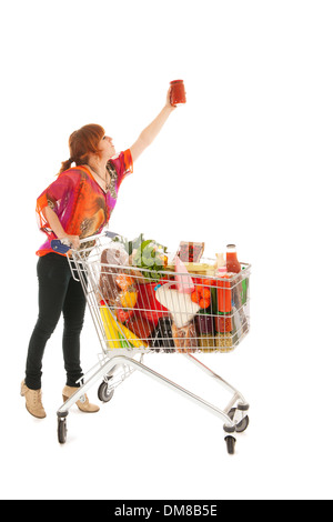 Frau mit Einkaufswagen voll mit Milch Lebensmittel Kommissionierung Glas-Topf-Pasta-Sauce isoliert auf weißem Hintergrund Stockfoto