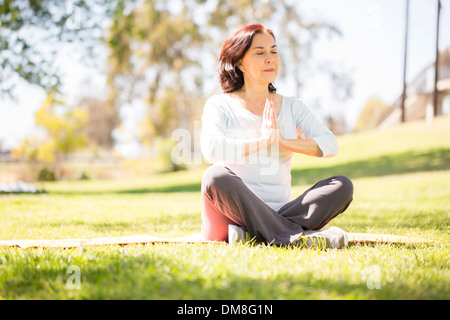 Reife Frau in Sukhasana Pose sitzt. Stockfoto