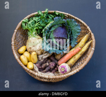 Wurzelgemüse und Kohlgewächse in einem Weidenkorb auf einer Tafel-Fläche Stockfoto