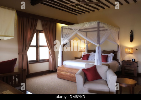 Bett mit Moskitonetz Baldachin in einem Schlafzimmer der Exploreans Ngorongoro Lodge in der Nähe des Ngorongoro Conservation Area Tansania Ostafrika Stockfoto