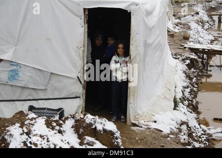 Rechtsanwaltskammer, Libanon. 12. Dezember 2013. Syrischer Flüchtling Stand in ihrem Zelt in einem Flüchtlingslager im Bekaa-Tal im Osten Libanon nach einem Schneesturm am 12. Dezember 2103. Der Schneesturm "Alexa" schlug Libanon Dienstagabend bringt Schnee in höheren Lagen und sintflutartigen Regen anderswo, begleitet von starken Winden. Die Vereinten Nationen und seine Partnerorganisationen Hilfsmaßnahmen für die mehr als 800.000 syrische Flüchtlinge im Libanon Hochfahren sind, die durch Regen, Schneefall und eisige Temperaturen als einen harten Winter Schüttelfrost waren, den Sturm bewegt sich in der gesamten Region, sagte UN-Beamten hier am Freitag. Stockfoto