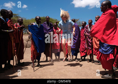 Ein junger Tourist tanzen mit Massai-Krieger in der Ngorongoro Conservation Area im Krater Hochland von Tansania Afrika Stockfoto