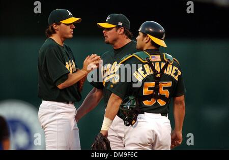 Oakland erster Basisspieler Jason Giambi und Catcher Ramon Hernandez sprechen mit der Startnummer Pitcher Barry Zito nach Yankee Jorge Posada fünften Inning Solo Homerun im Spiel drei der American League West Division Playoffs zwischen den Oakland Athletics und den New York Yankees an Network Associates Coliseum Samstag, 13. Oktober 2001. Sacramento Bee Foto von Jose Luis Villegas.  / Stockfoto