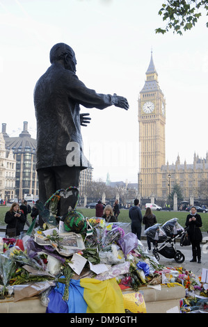 Blumen und Nachrichten blieben an Nelson Mandela Statue in Parliament Square, London, die nach seinem Tod am 5. Dezember 2013. Stockfoto