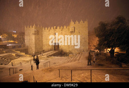 Jerusalem, Jerusalem, Palästina. 12. Dezember 2013. Die Menschen gehen vor Damaskus-Tor während eines Schneesturms in der Jerusalemer Altstadt am 12. Dezember 2013. Jerusalem ist bedeckt mit Schnee Donnerstag, der schwersten Schneesturm trifft der City seit 1953 als Meteorologen genannt Credit: Saeed Qaq/APA Images/ZUMAPRESS.com/Alamy Live News Stockfoto