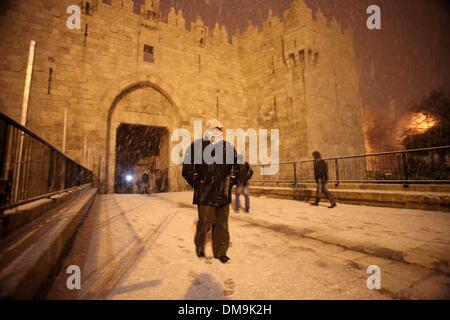 Jerusalem, Jerusalem, Palästina. 12. Dezember 2013. Die Menschen gehen vor Damaskus-Tor während eines Schneesturms in der Jerusalemer Altstadt am 12. Dezember 2013. Jerusalem ist bedeckt mit Schnee Donnerstag, der schwersten Schneesturm trifft der City seit 1953 als Meteorologen genannt Credit: Saeed Qaq/APA Images/ZUMAPRESS.com/Alamy Live News Stockfoto