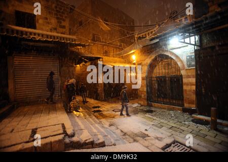 Jerusalem, Jerusalem, Palästina. 12. Dezember 2013. Palästinenser Fuß in einer Straße, die während eines Schneesturms in der Jerusalemer Altstadt am 12. Dezember 2013 mit Schnee bedeckt. Jerusalem ist bedeckt mit Schnee Donnerstag, der schwersten Schneesturm trifft der City seit 1953 als Meteorologen genannt Credit: Saeed Qaq/APA Images/ZUMAPRESS.com/Alamy Live News Stockfoto