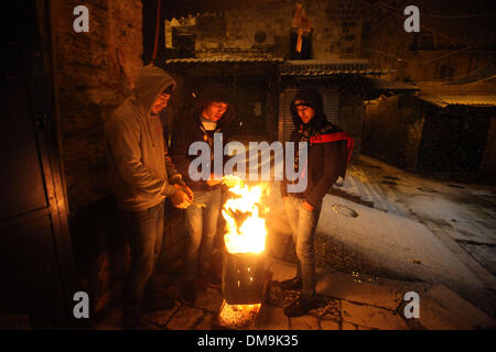 Jerusalem, Jerusalem, Palästina. 12. Dezember 2013. Palästinenser können Brennholz um sich während eines Schneesturms in der Jerusalemer Altstadt am 12. Dezember 2013 zu wärmen. Jerusalem ist bedeckt mit Schnee Donnerstag, der schwersten Schneesturm trifft der City seit 1953 als Meteorologen genannt Credit: Saeed Qaq/APA Images/ZUMAPRESS.com/Alamy Live News Stockfoto