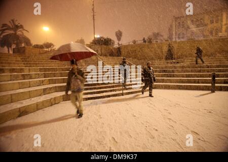 Jerusalem, Jerusalem, Palästina. 12. Dezember 2013. Die Menschen gehen vor Damaskus-Tor während eines Schneesturms in der Jerusalemer Altstadt am 12. Dezember 2013. Jerusalem ist bedeckt mit Schnee Donnerstag, der schwersten Schneesturm trifft der City seit 1953 als Meteorologen genannt Credit: Saeed Qaq/APA Images/ZUMAPRESS.com/Alamy Live News Stockfoto