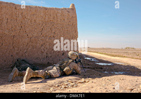 Ein US-Marine umfasst ein offenes Feld mit einem leichten Maschinengewehr M249 bei einem Feuergefecht mit Aufständischen 4. Dezember 2013 in der Nähe von Bari Gul Basar im Bezirk Nad Ali, Provinz Helmand, Afghanistan. Stockfoto